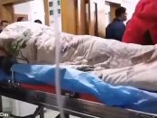 Pacient zvârcolindu-se incontrolabil pe un cărucior de spital în Wuhan
